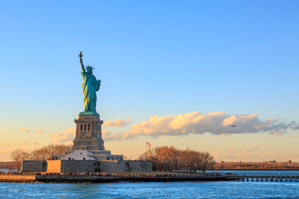 Iconic Statue of Liberty with Ellis Island in the background