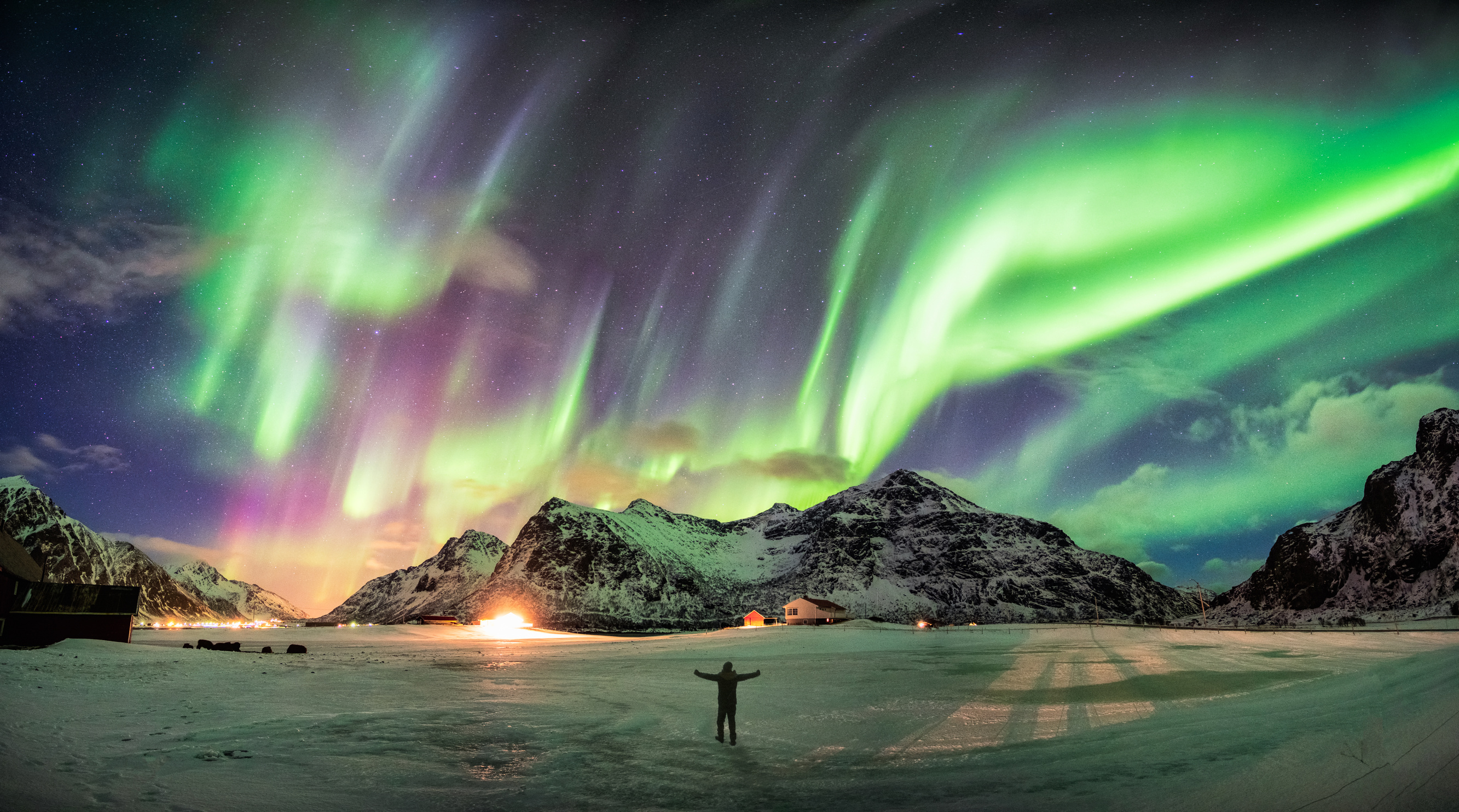 Spectacular view of the aurora borealis over a snowy landscape, perfect for bucket list adventures.